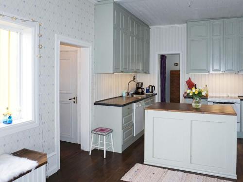a kitchen with white cabinets and a counter top at Pleasant holiday home for 8 guests in Vimmerby