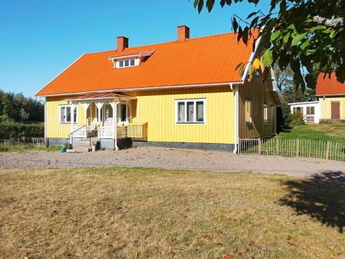 a yellow house with an orange roof at Pleasant holiday home for 8 guests in Vimmerby