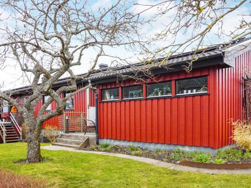 a red house with a tree in the yard at Apartment in center of Strömstad in Strömstad