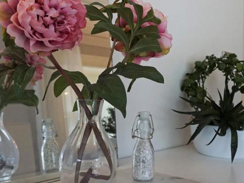 a glass vase with flowers on a table at 5 person holiday home in Nösund in Nösund