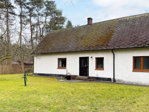 a white house with a black roof and a yard at 5 person holiday home in LÖDDEKÖPINGE in Löddeköpinge
