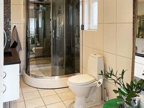 a bathroom with a shower and a white toilet at 5 person holiday home in LÖDDEKÖPINGE in Löddeköpinge
