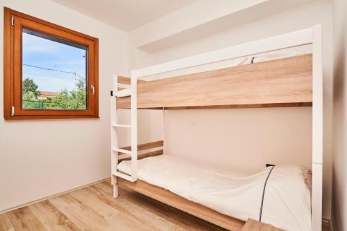 a bedroom with bunk beds and a window at Villas Montrin in Kaštel