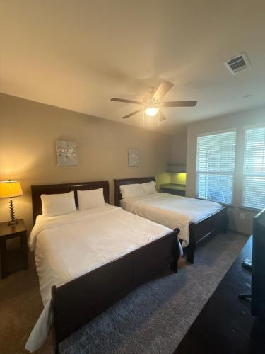 une chambre avec deux lits et un ventilateur de plafond dans l'établissement Resort Style Apartment/Home - The Woodlands, à The Woodlands