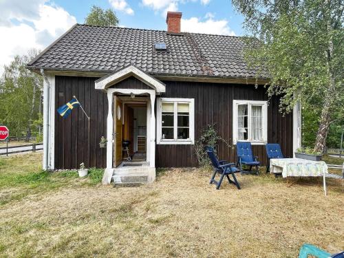 a small house with a table and chairs in front of it at 5 person holiday home in LINNERYD KRONOBERGS LÄN in Linneryd