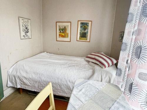 a bedroom with a bed and two pictures on the wall at 5 person holiday home in LINNERYD KRONOBERGS LÄN in Linneryd