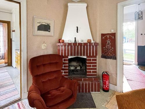 a living room with a chair and a fireplace at 5 person holiday home in LINNERYD KRONOBERGS LÄN in Linneryd