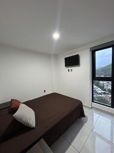 a bedroom with a bed and a flat screen tv at Torres colon in Guadalajara