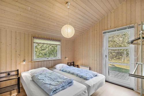 a bedroom with two beds in a room with a window at 3632-Nexo-Hedevej-12 in Neksø
