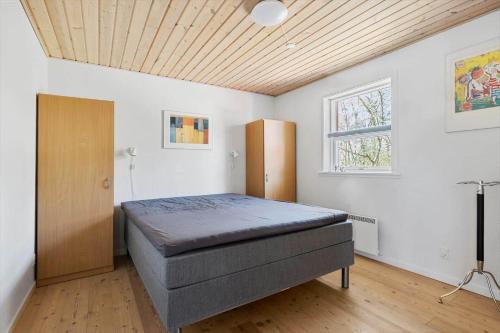 a bedroom with a bed and a wooden ceiling at 3712-Nexo-Aastien-8 in Neksø