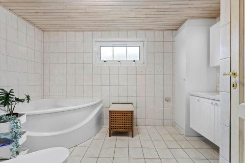 a white bathroom with a tub and a window at HA286-Saeby-Nellemannsvej-12 in Sæby