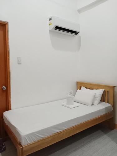 a bed in a room with a white wall at Chery's Guesthouse in San Juan