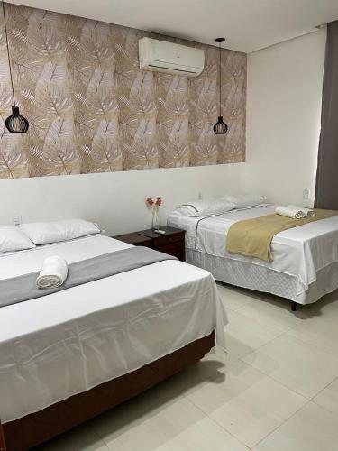 a bedroom with two beds and a wall at CASA CONFORTÁVEL COM 4 QUARTOS EM ALTER DO CHÃO in Alter do Chao