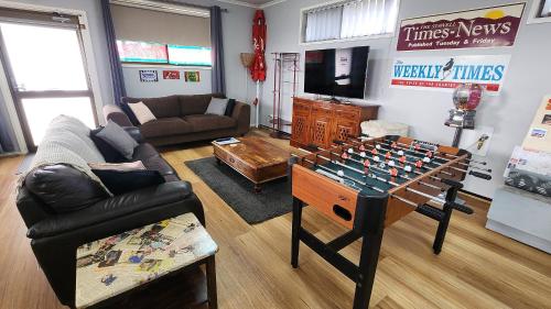 a living room with a foosball table in the middle of a room at The Corner Store B&B in Stawell