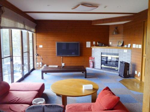 a living room with a fireplace and a tv at Cottage Self-sufficiency Seya Highlands - Vacation STAY 91982v in Miyazu