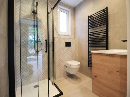 ein Badezimmer mit Toilette und Glasdusche in der Unterkunft Modern Lakeview Cottage in Veluwe in Hoenderloo