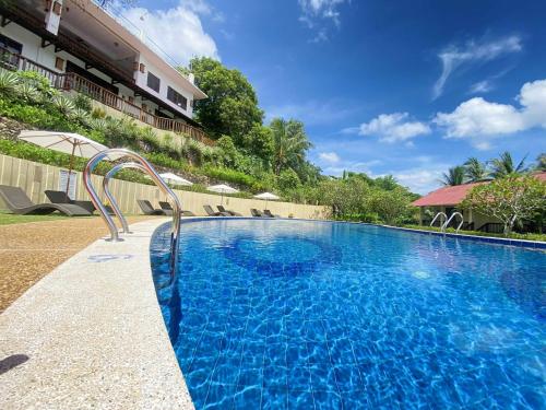 a large blue swimming pool in front of a building at Asia Grand View Hotel in Coron