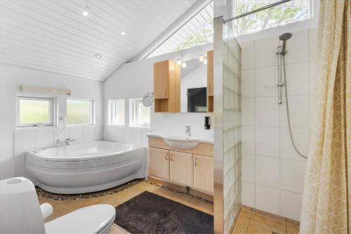 a bathroom with a tub and a sink and a toilet at OH551-Hadsund-Ved-Fruerlund-35 in Hadsund