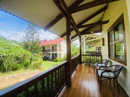 a balcony with two chairs and a view of a house at Asia Grand View Hotel in Coron