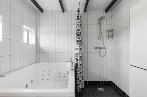 a white bathroom with a tub and a shower at FY370-Otterup-Platanvej-23 in Otterup