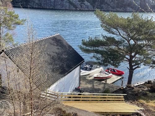 a house with boats parked on the shore of a lake at 6 person holiday home in Rubbestadneset in Rubbestadneset