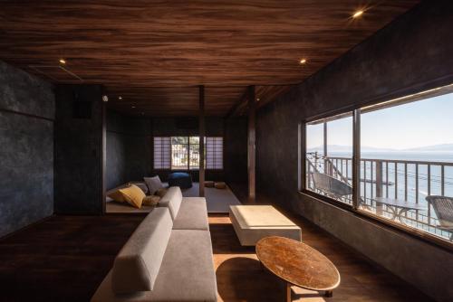 a living room with a couch and a large window at the Terrace 長浜 in Kure