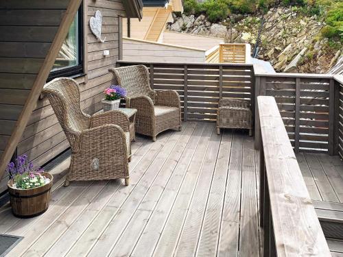 a patio with wicker chairs and a bench on a deck at 8 person holiday home in Urangsvåg in Ervik