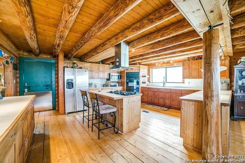 a large kitchen with wooden floors and wooden ceilings at The Walpole Cabin in Mico
