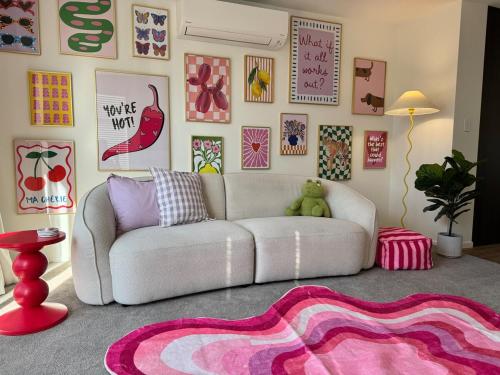 a living room with a white couch and a pink rug at Colour Burst Townhouse in Christchurch