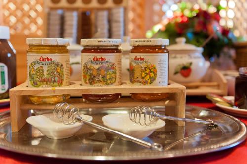 a table with two spoons and jars of honey at Winklmoos Sonnenalm in Reit im Winkl