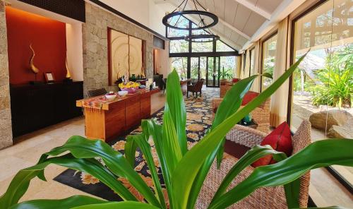 a living room with a plant in the middle of it at Banyan Tree Cabo Marques in Acapulco