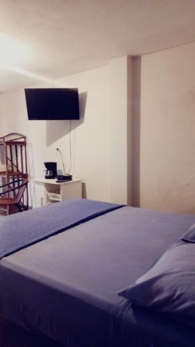 a bedroom with a blue bed and a chair at Villa Naylamp loft en las pocitas in Máncora