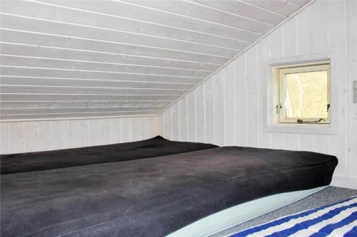 a bed in a white room with a window at FY320-Nyborg-Strandskovvej-9 in Nyborg