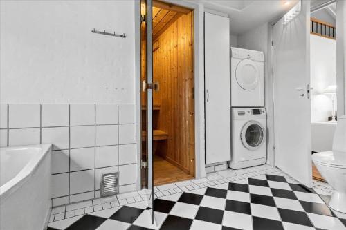 baño con lavadora y suelo a cuadros en FY231-Otterup-Strandparken-71, en Otterup