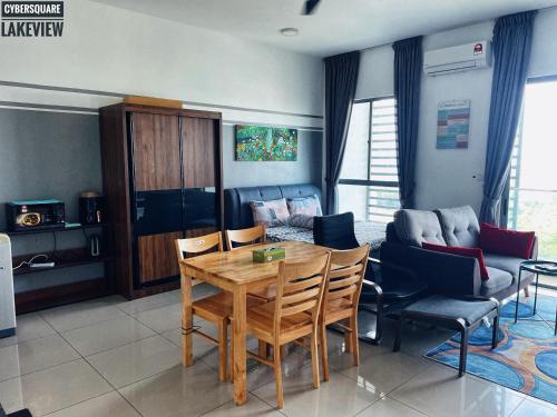 a living room with a table and chairs and a couch at Cybersquare Lakeview with Netflix and Disney Hotstar in Cyberjaya