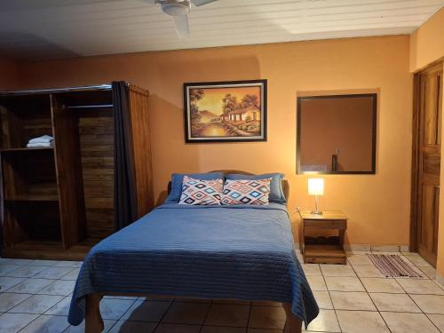 Un dormitorio con una cama con un edredón azul. en Apartamentos Quepos Malichita Studio, en Quepos