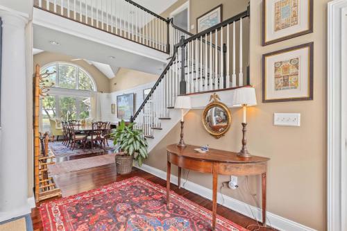 aoyer with a staircase and a table with a mirror at Boview Hall- Poo l Hot Tub-15 mins to Kiawah in Johns Island