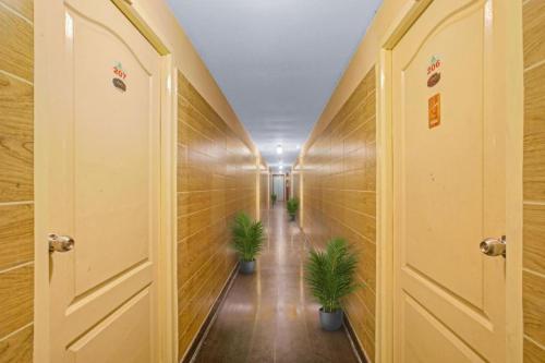 a corridor with two plants in a hallway at MGR Residency in Puducherry