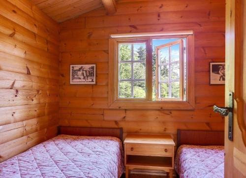 a bedroom with two beds in a log cabin at LF21543-Spottrup-Tyttebaervej-10 in Lem