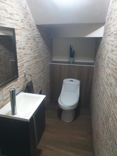 a bathroom with a white toilet and a sink at Casa paseo cumbres in Monterrey