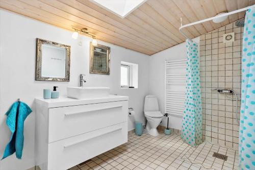 a bathroom with a white sink and a toilet at LF14198-Roslev-Bagvejen-2 in Roslev