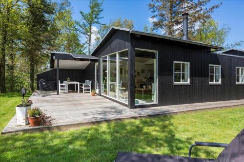 a black tiny house with a deck at LF14198-Roslev-Bagvejen-2 in Roslev