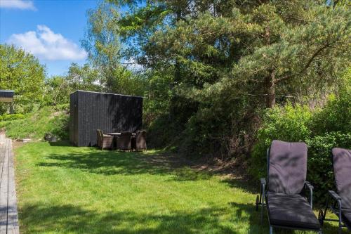 a yard with two chairs and a table in the grass at LF14198-Roslev-Bagvejen-2 in Roslev