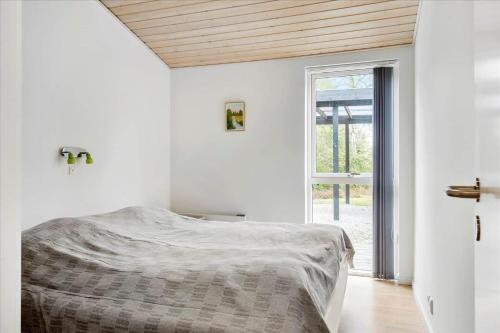 a white bedroom with a bed and a window at LF15198-Hojslev-Bronzehojen-7 in Højslev