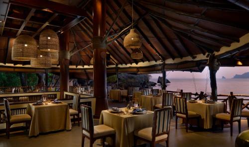 a restaurant with tables and chairs with a view of the ocean at Rayavadee in Railay Beach