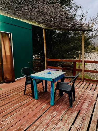 une table bleue et deux chaises sur une terrasse dans l'établissement Cabañas by Taos, à Rivadavia