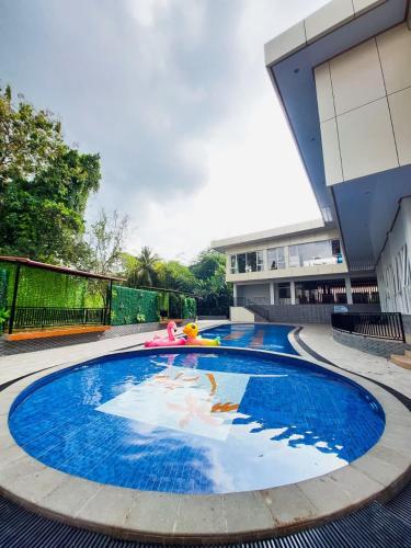 a large swimming pool with a toy in a building at Prima SR Hotel & Convention Yogyakarta in Yogyakarta