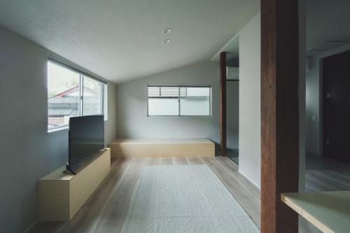 an empty living room with a tv and a window at Aso La Vista 阿蘇の家 in Aso