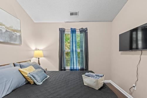 a bedroom with a bed and a flat screen tv at Spectacular Quiet Townhome with Modern Comfort in Stockbridge