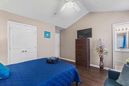 a bedroom with a blue bed and a tv at Spectacular Quiet Townhome with Modern Comfort in Stockbridge